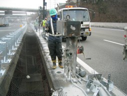 あと施工アンカー工事　交通安全施設工事　各種コンクリート切断工事　自動車道　防護柵改良工事　削岩機穿孔状況