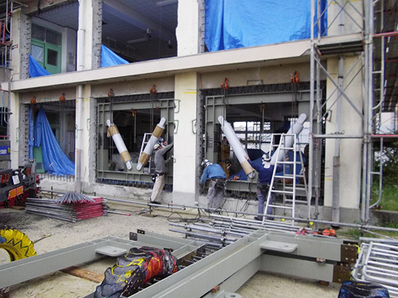 耐震補強工事（建築耐震）　市立藤井寺小学校1・13号棟地震補強工事　枠付き免震ダンパー設置後、設置位置の微調整状況写真